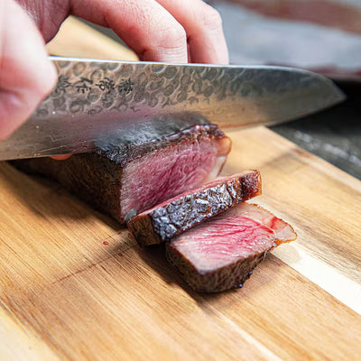 Slicing a seared Holy Wagyu kosher Wagyu steak on a wooden board