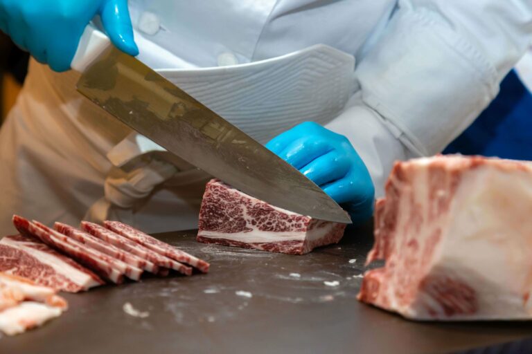 butcher cutting and preparing marbled wagyu beef